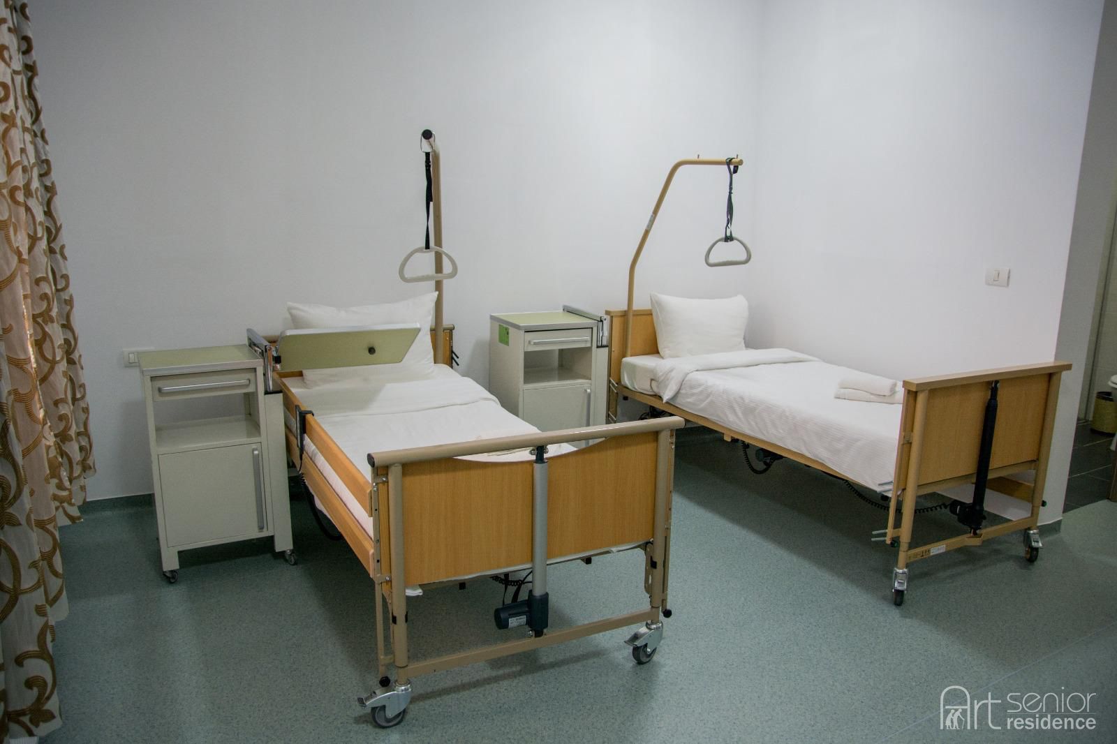 Cameră cu două paturi medicale și noptiere cu funcții medicale