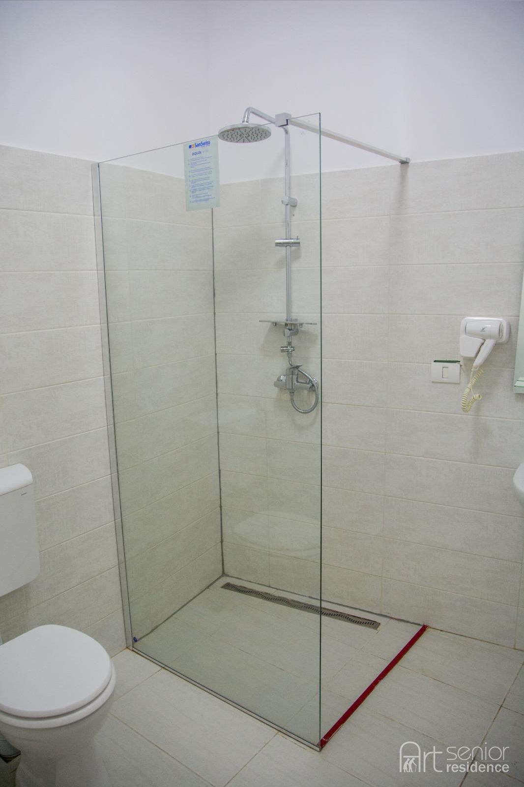 Baie cu duș fără prag și toaletă, ușor accesibilă