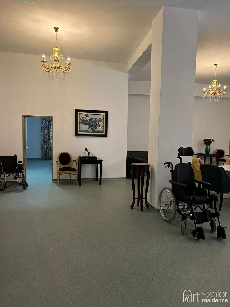Spațiu comun cu mese, scaune și acces direct spre camere