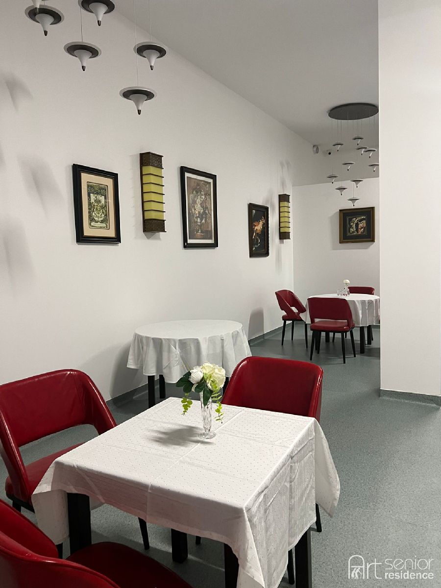 Masă pentru două persoane, cu flori, în sala de mese